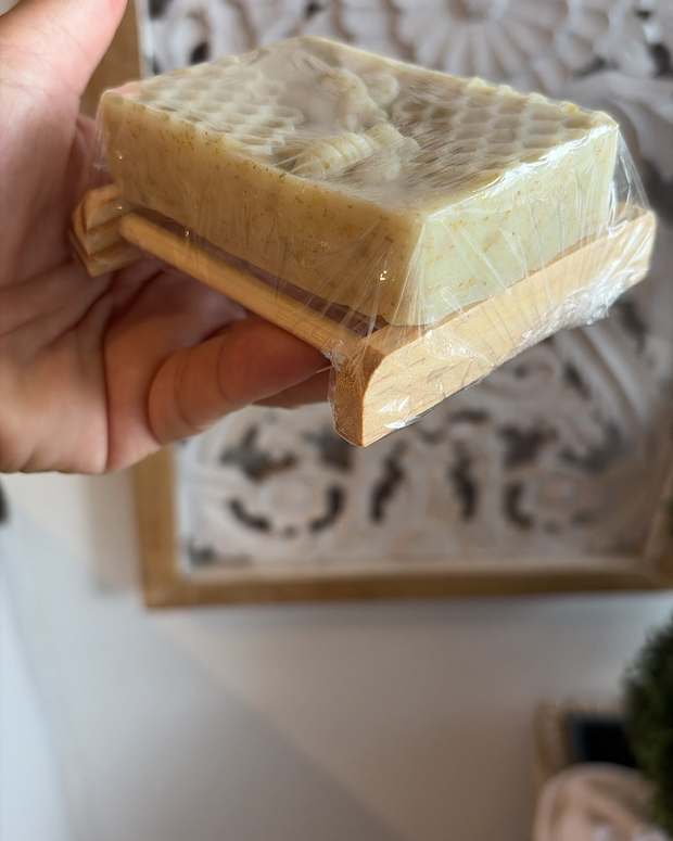 Honeycomb glycerin soap resting on a slatted wooden soap dish